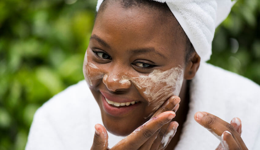 Woman applying foaming cleanser to face